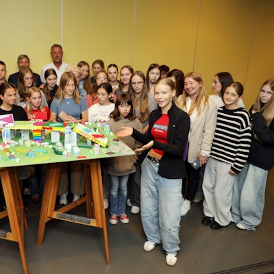 Die Schülergruppe steht um einen Modellbau einer Brücke.