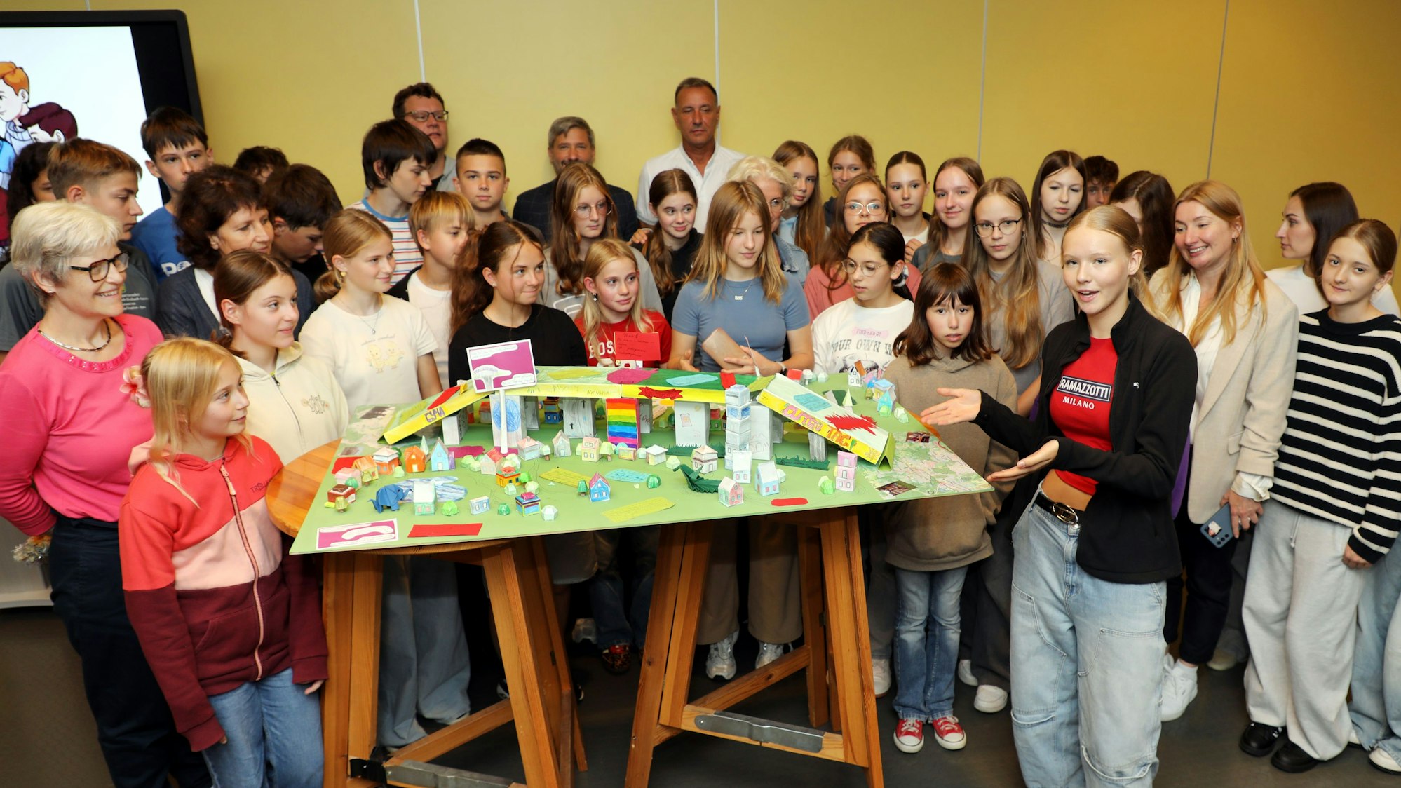 Die Schülergruppe steht um einen Modellbau einer Brücke.