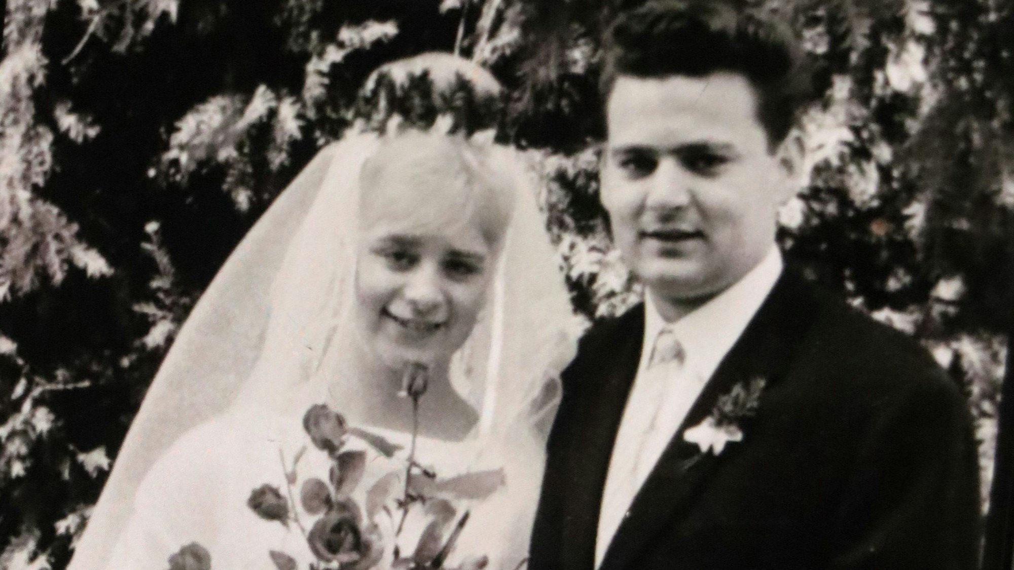 Zu sehen ist ein Ehepaar am Tag seiner Hochzeit in schwarz-weiß.