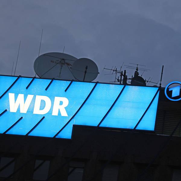 Ein Logo des WDR (Westdeutscher Rundfunk) leuchtet auf dem Dach des Senders.