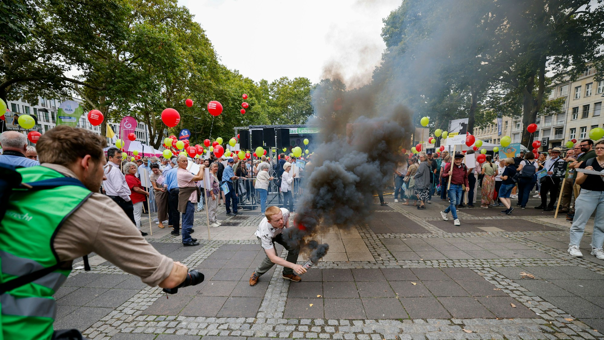 Ein Gegendemonstrant zündet einen Rauchtopf.