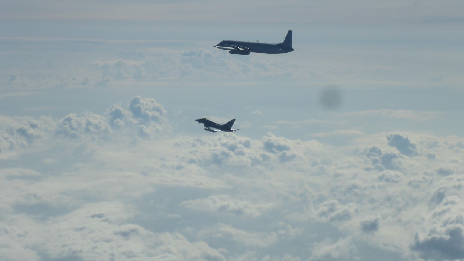 Ein Eurofighter und ein russisches Flugzeug fliegen im August 2025 über der Ostsee.