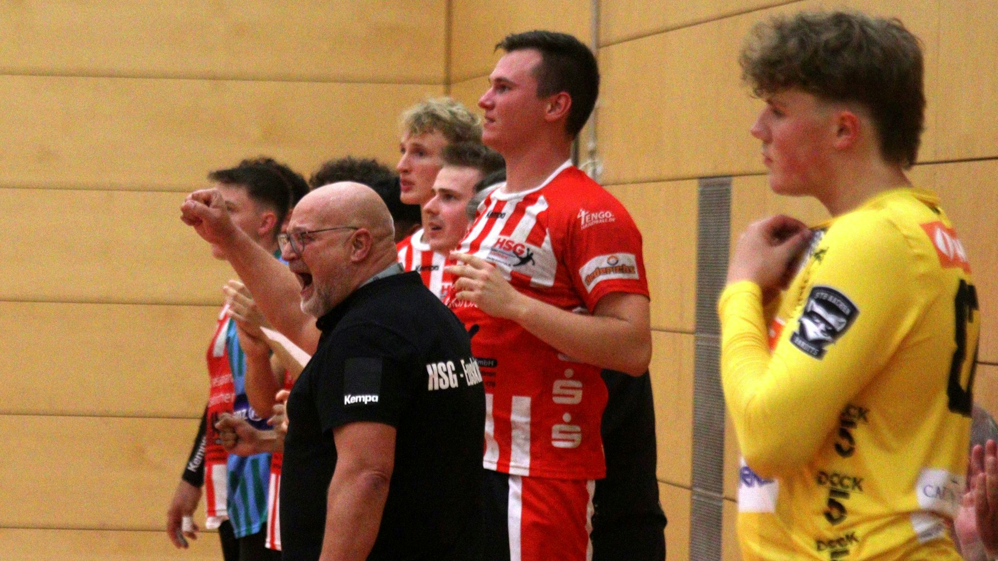 Frank Rösgen jubelt, seine Spieler schauen noch ungläubig. Im Vordergrund blickt der Torwart von Aachen traurig drein.