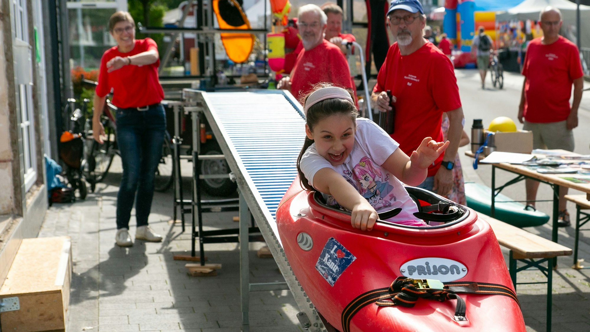 Das Foto zeigt ein Mädchen in einem Kajak, das eine Rollenbahn hinunter rutscht.