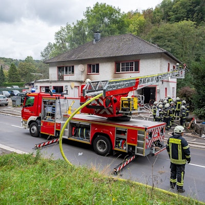 Das Foto zeigt Einsatzkräfte der Feuerwehr vor einem Haus.