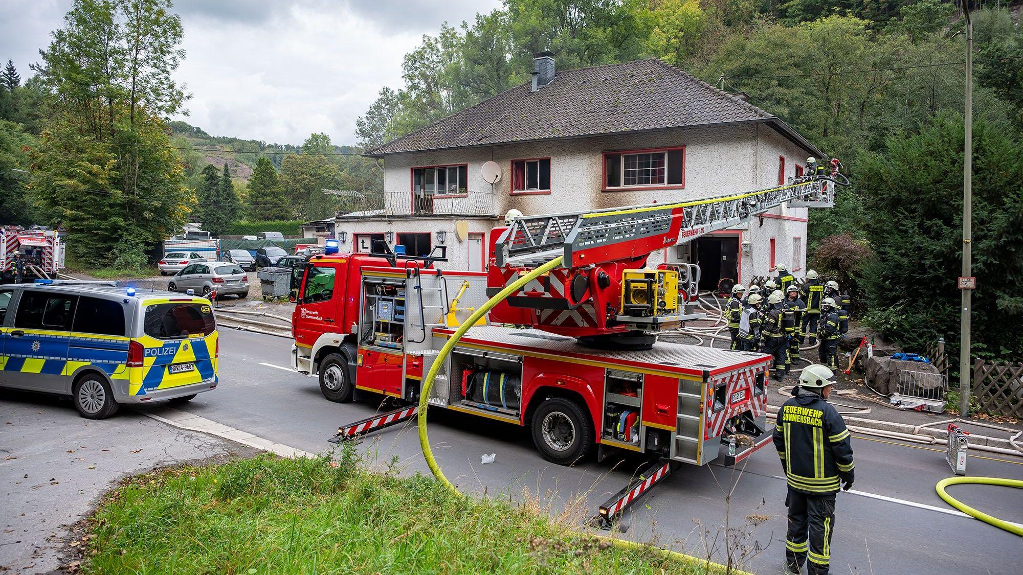 Das Foto zeigt Einsatzkräfte der Feuerwehr vor einem Haus.