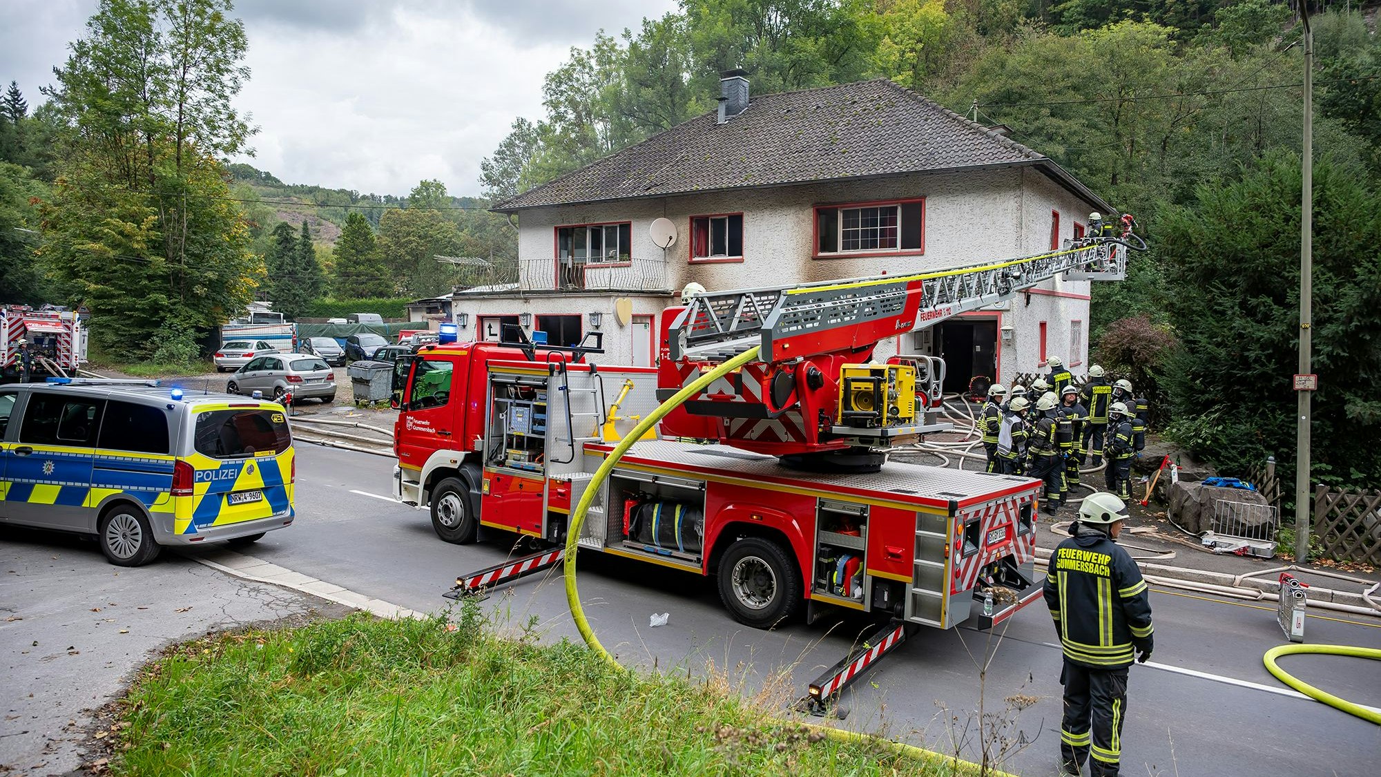 Das Foto zeigt Einsatzkräfte der Feuerwehr vor einem Haus.
