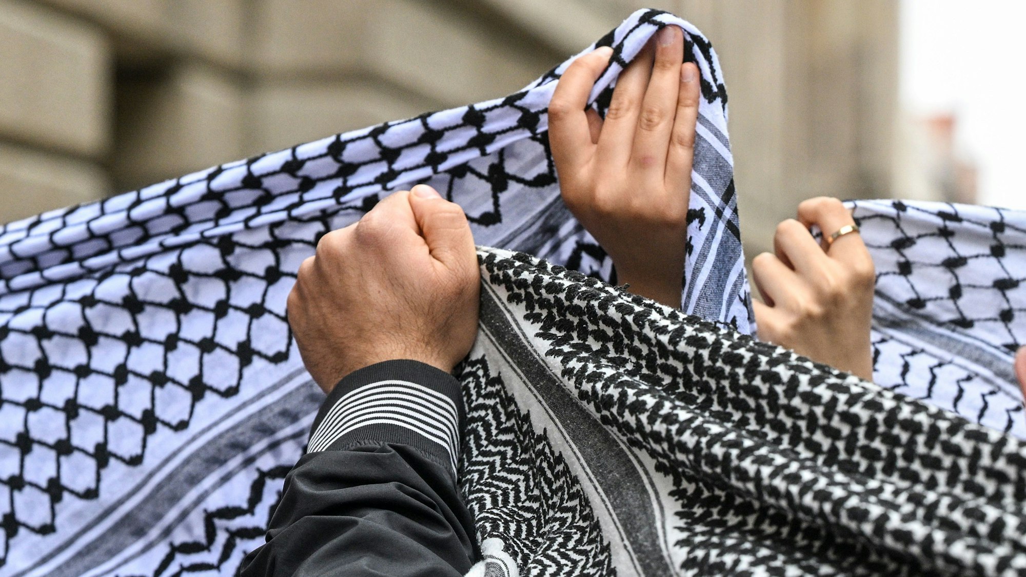 ARCHIV - 03.06.2024, Berlin: Pro-Palästinensische Studenten tragen bei einer Demonstration unter dem Motto „Hands of Student Rights“ gegen eine Verschärfung des Hochschulgesetz Palästinensertücher. Im Zuge des Nahostkonfliktes hat sich die Kufiya zu einem Symbol für die Palästinenser entwickelt. (zu dpa: «Gedenkstätte darf Gästen mit «Pali-Tuch» Zutritt verwehren») Foto: Jens Kalaene/dpa +++ dpa-Bildfunk +++