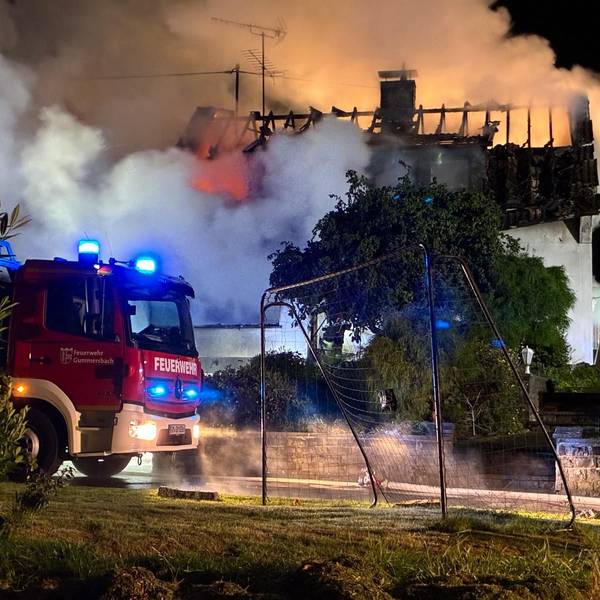 Ein Haus steht in Flammen, dichter Qualm steigt auf.