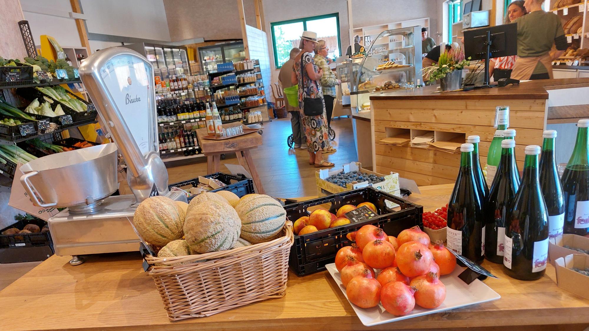 Obst, Gemüse und Getränke auf großen Holztischen.