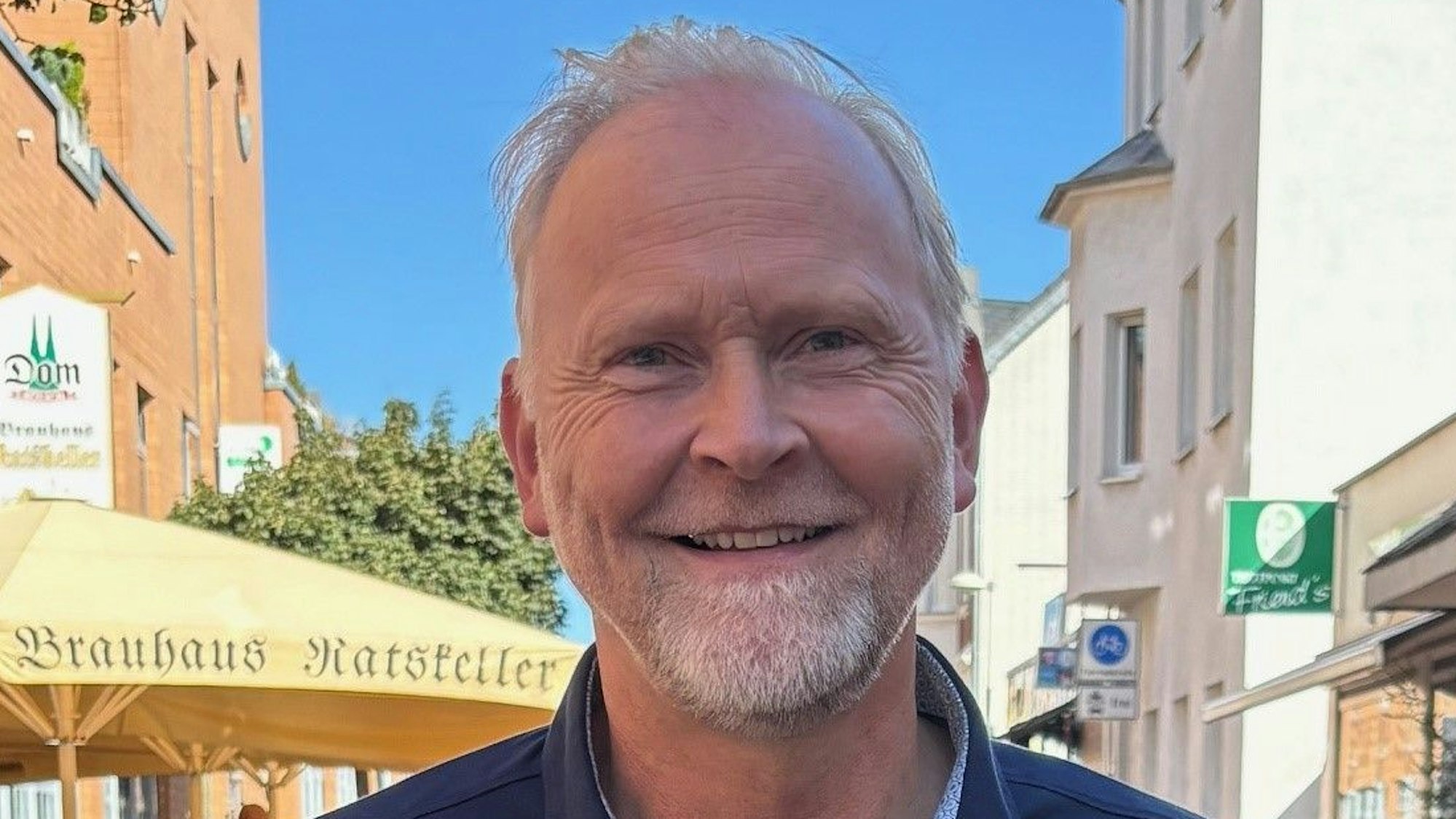 Auf dem Bild ist das Portrait von Gerd Koslowski zu sehen, er trägt ein blaues Hemd.