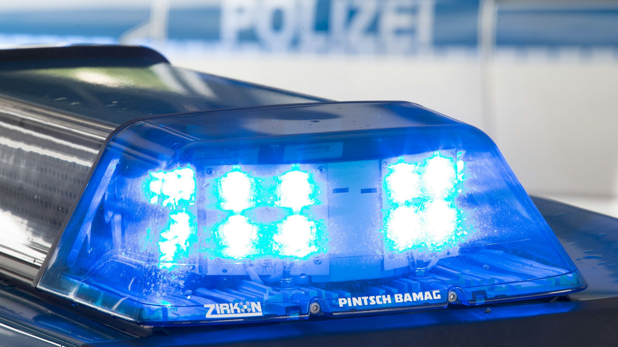 Ein Blaulicht leuchtet auf dem Dach eines Polizeiwagens.