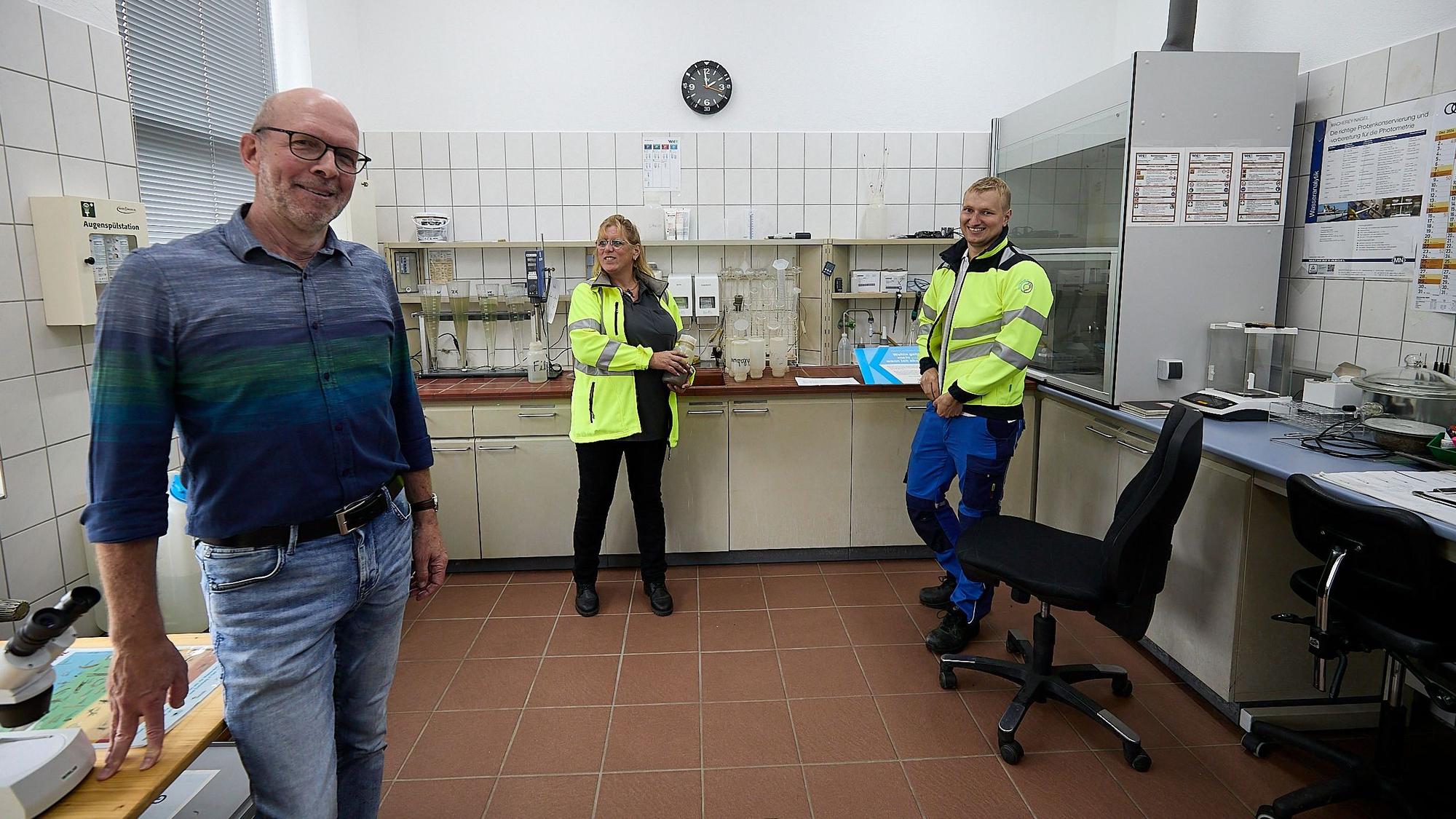 Zwei Männer und eine Frau stehen im Labor der Kläranlage in Gemünd.