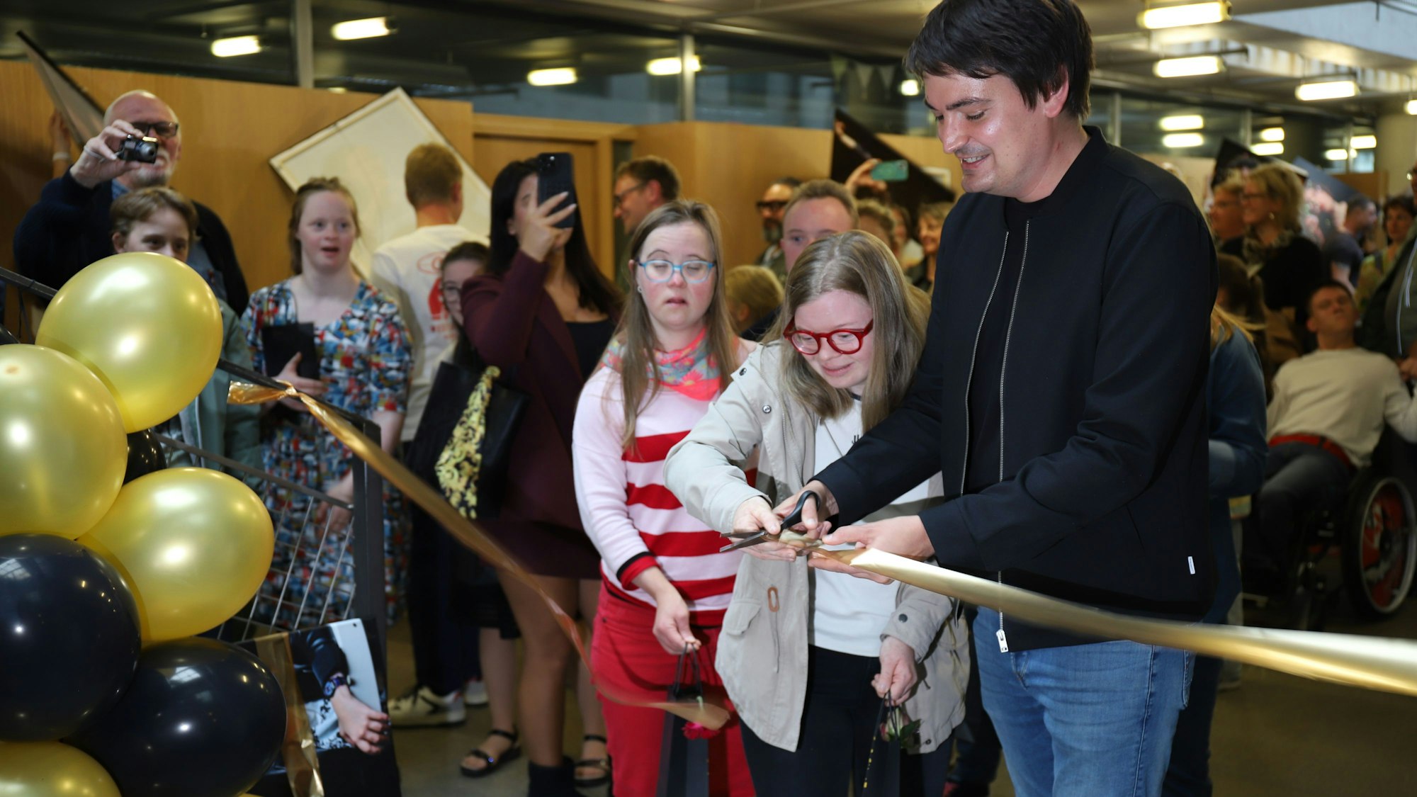 Bürgermeister Mario Dahm schnitt das symbolische goldene Band durch, erstmals konnten die Models ihre Bilder sehen.