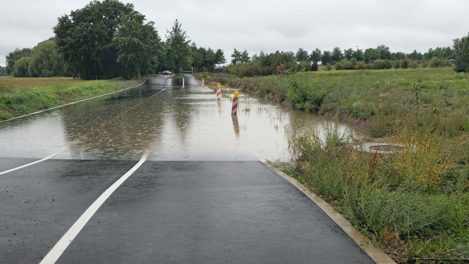 Die Senke in der Straße zum Wassersportsee bei Zülpich ist voll Wasser gelaufen