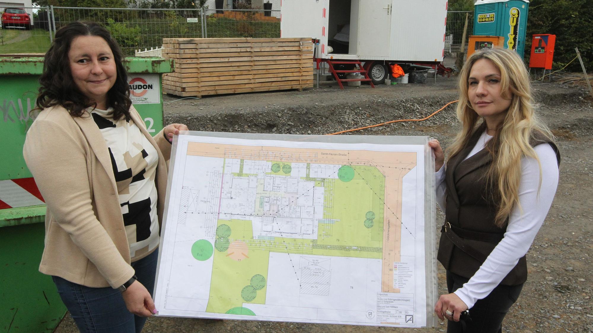 Kita-Leiterin Olesja Heinitz (r.) und ihre Stellvertreterin Vera Radke mit dem Architektenplan für den Neubau.