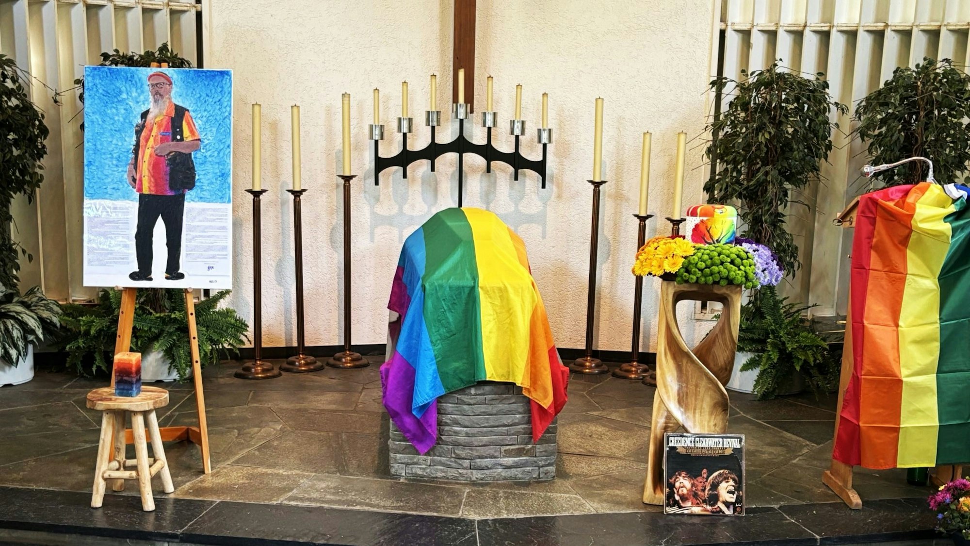 Blick auf eine bunte Urne und bunte Tücher in einer Friedhofshalle