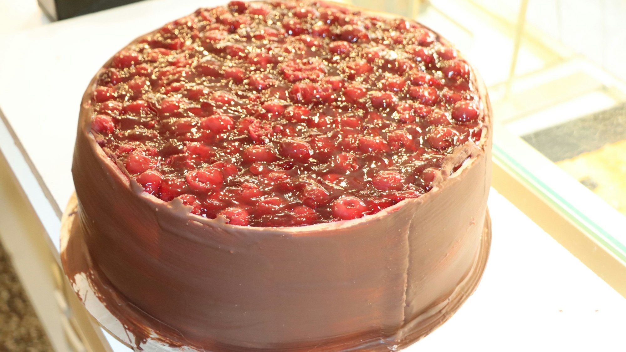 Zu sehen ist eine Torte mit Beeren und Schokolade.