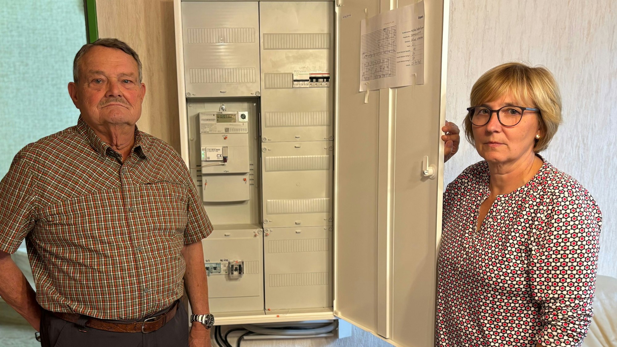 Die Eheleute Sanders vor ihrem geöffneten Verteilerschrank.