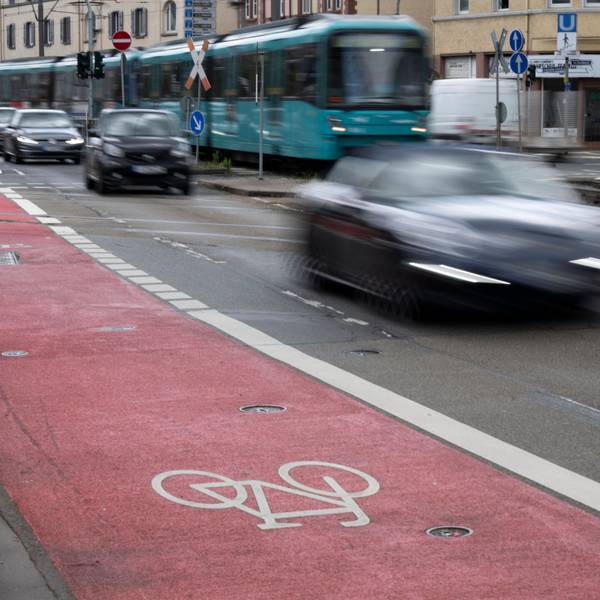 Ein rosafarbener Radweg auf einer Straße.