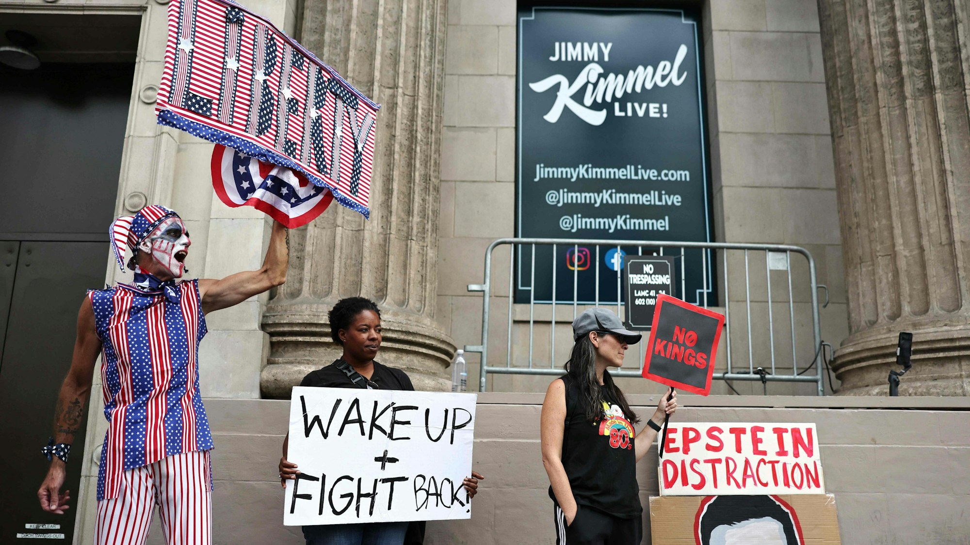 Demonstrierende halten Plakate in die Luft.