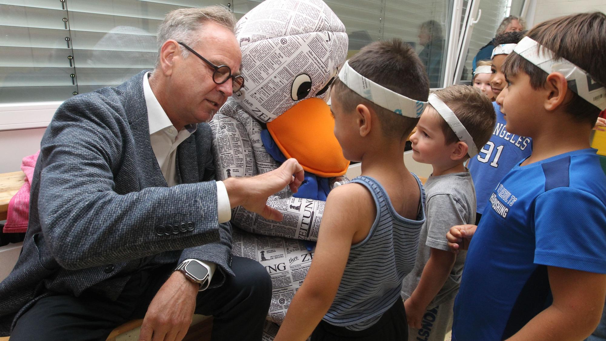 KSK-Vertreter Peter Schaffrath wollte genau wissen, wie die Kinder ihre Stirnbänder gebastelt haben.
