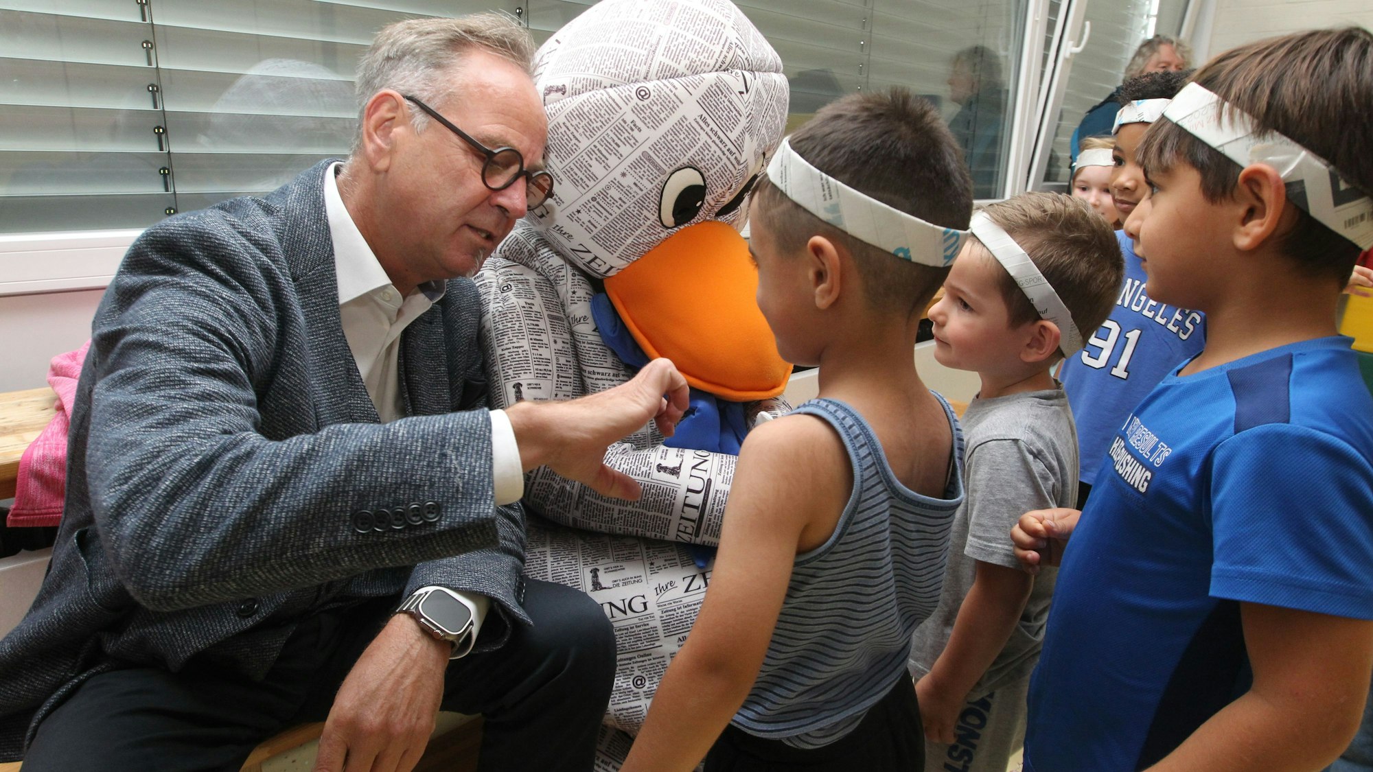 KSK-Vertreter Peter Schaffrath wollte genau wissen, wie die Kinder ihre Stirnbänder gebastelt haben.