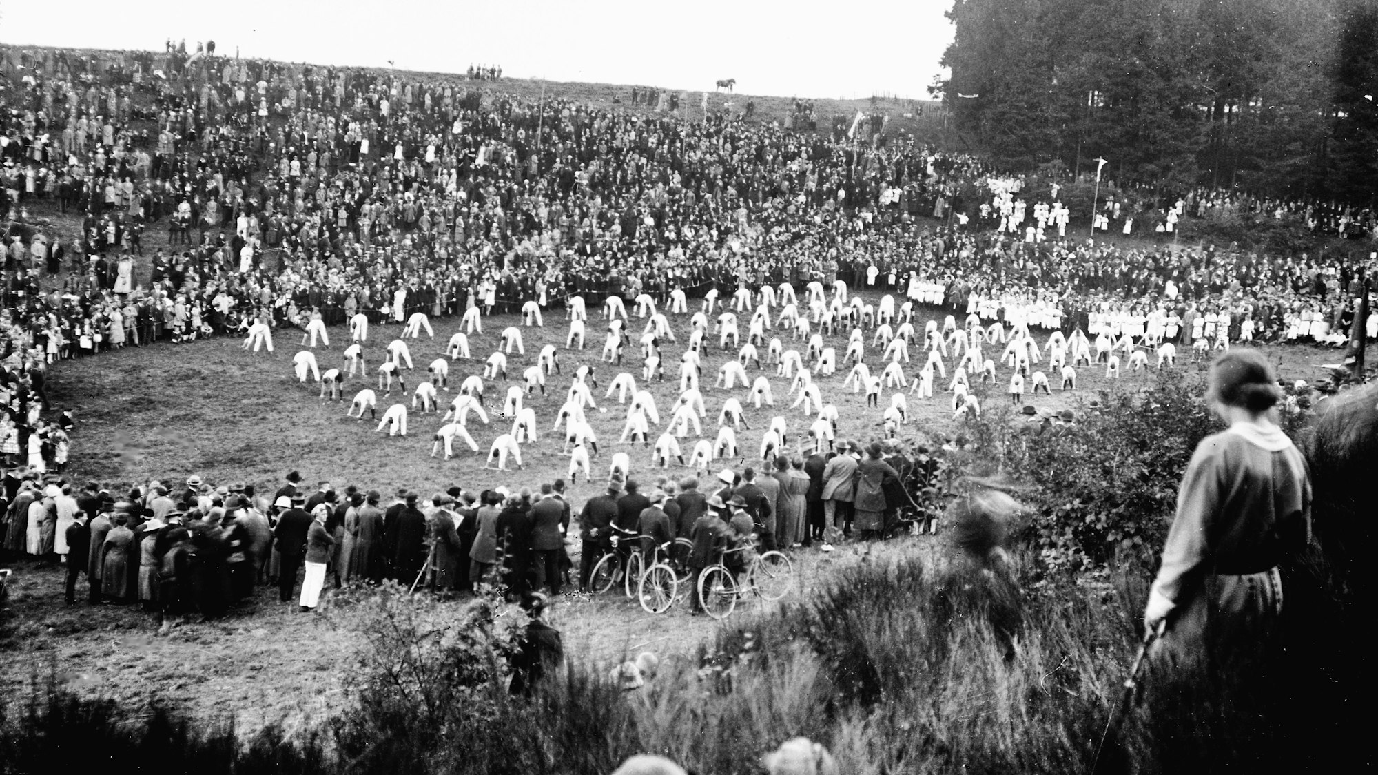 Das Schwarz-Weiß Foto zeigt Turner auf einer Wiese, umgeben von zahlreichen Zuschauern.