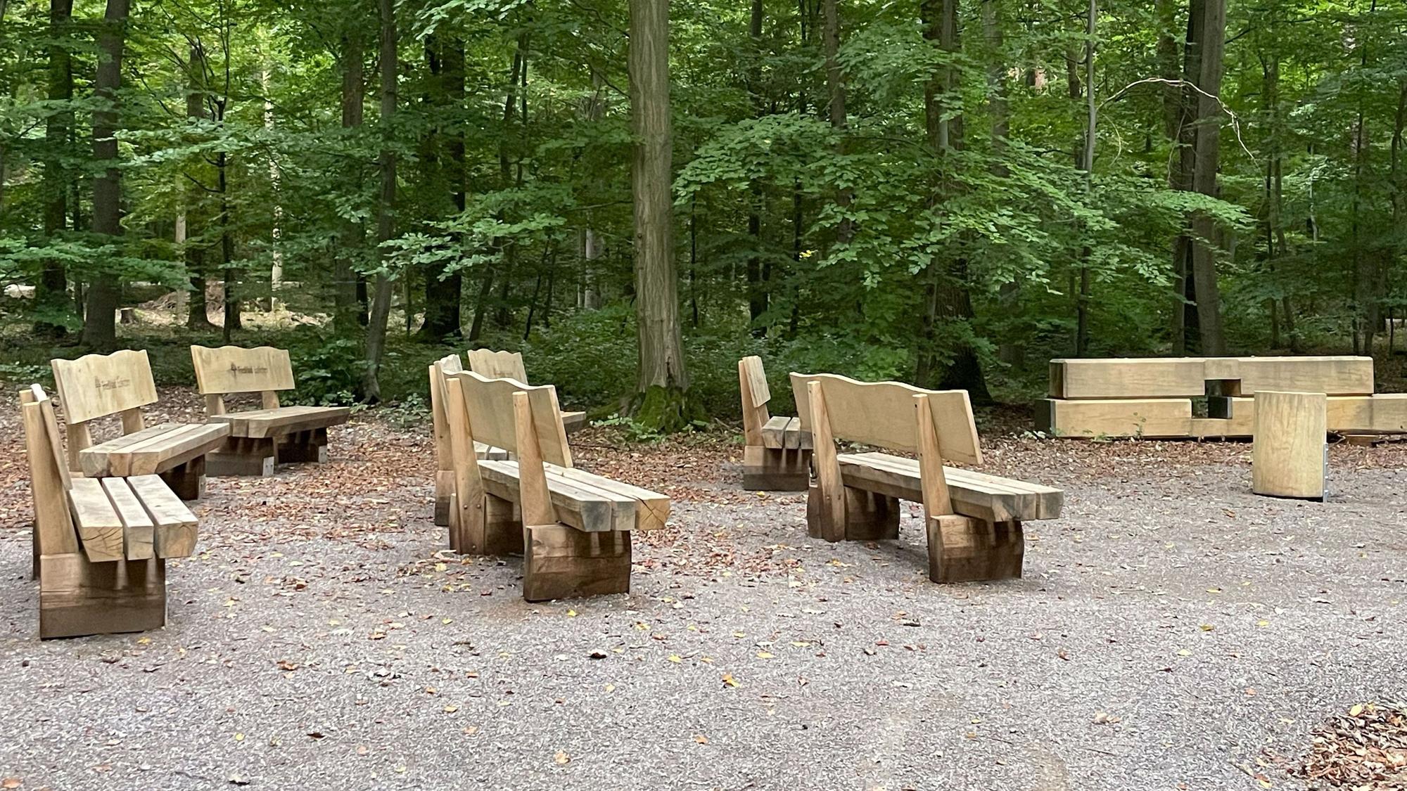 Auf dem Bild sind acht Holzbänke zu sehen.
