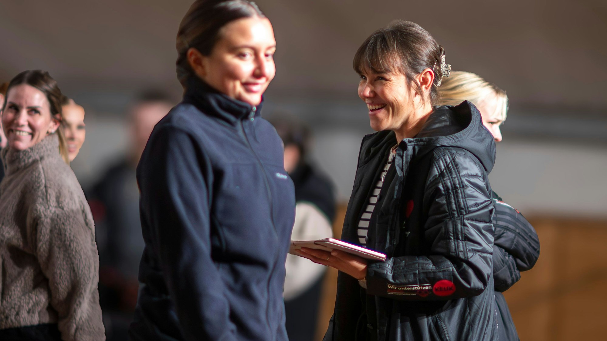 Das Bild zeigt die Trainerin mit einem Tablet in der Hand.