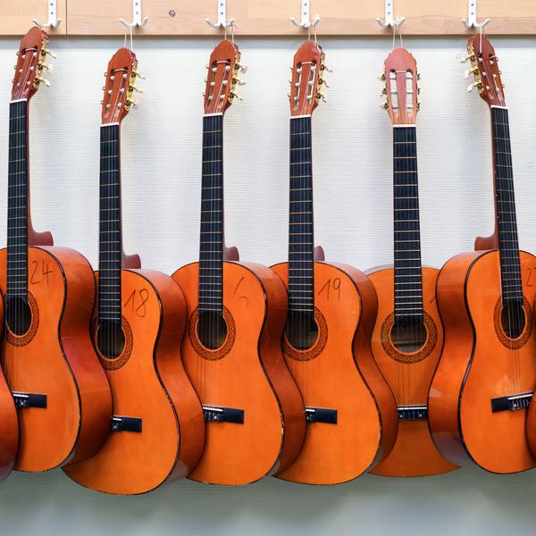 Symbolbild: Nummerierte Gitarren hängen an einer Wand.