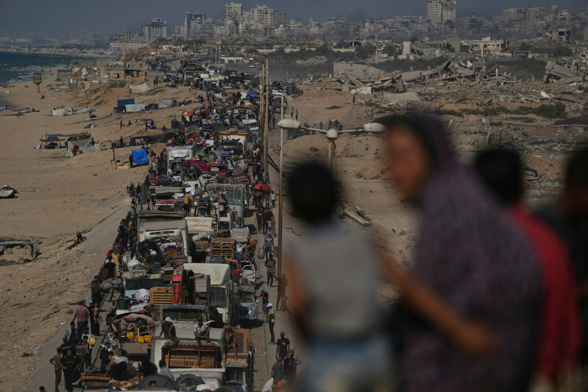 Vertriebene Palästinenser fliehen zu Fuß und in Fahrzeugen aus dem nördlichen Gazastreifen und tragen ihre Habseligkeiten entlang der Küstenstraße in der Nähe des Wadi Gaza.