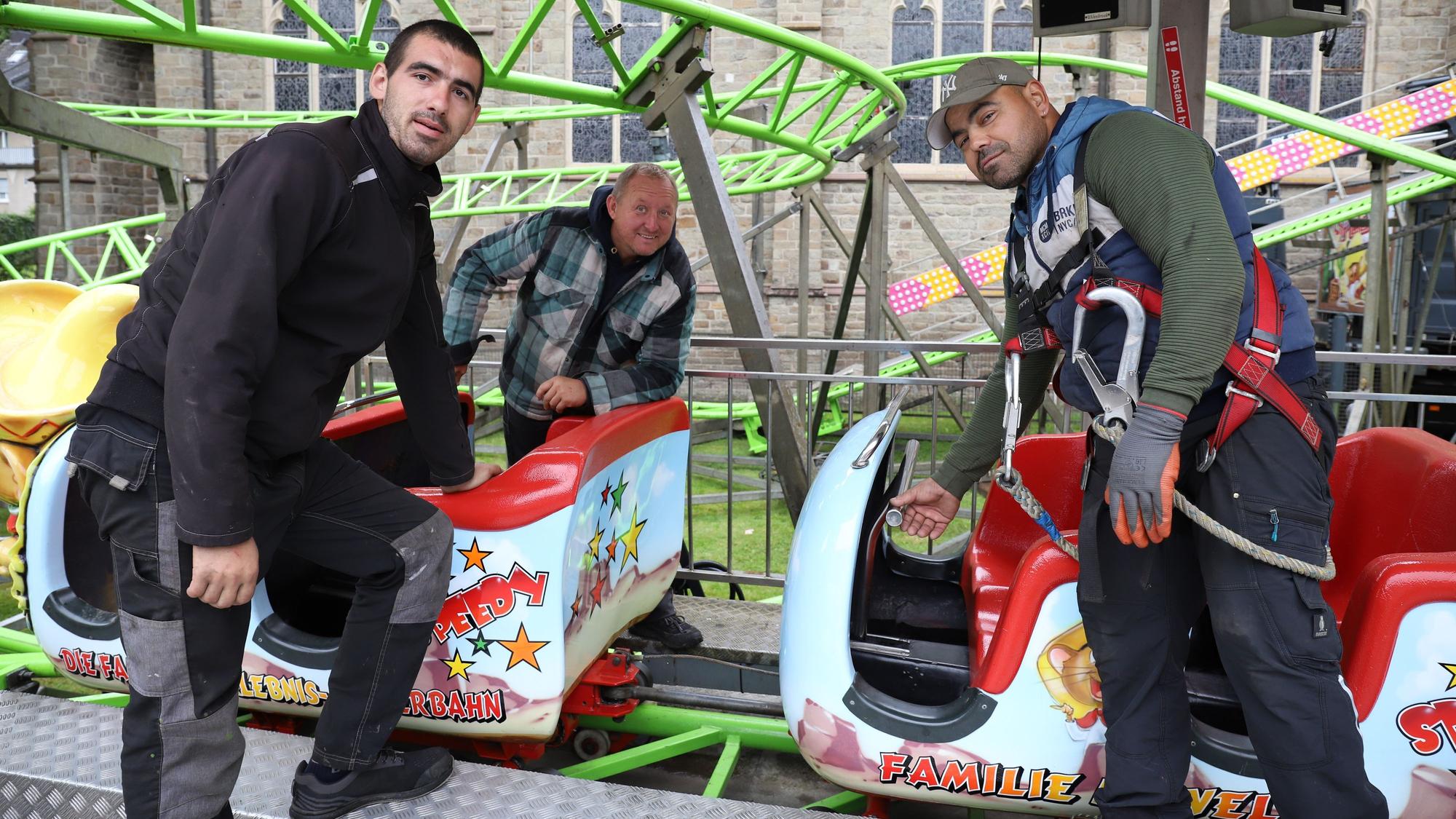 Victor Gusanu (l.) und Claudio Johann nehmen ihren Chef Marco Welte in die Mitte, sie bauen gerade die Achterbahn „Speedy“ auf.