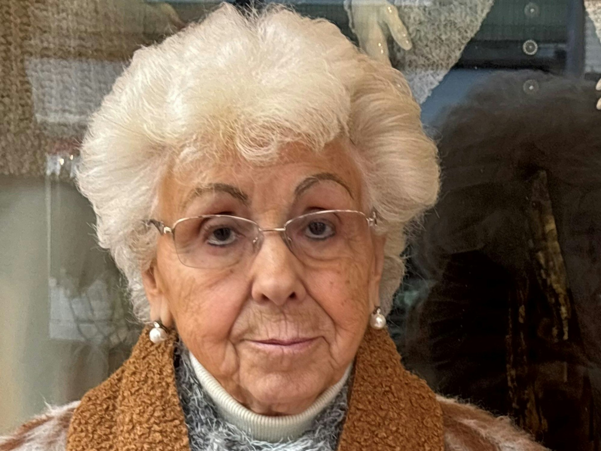 Auf dem Bild ist eine ältere Dame mit weißen Haaren zu sehen.