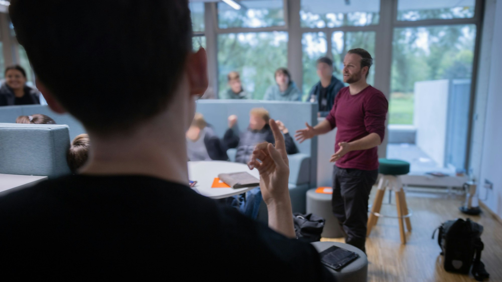 Ein Lehrer steht vor Schülern und erklärt etwas.