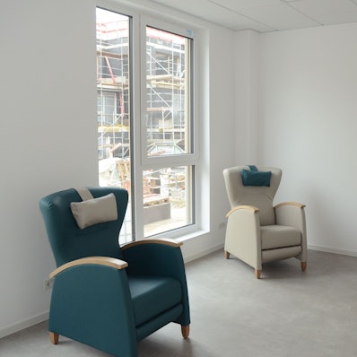 Zwei Sessel und ein Bett in einem Zimmer.