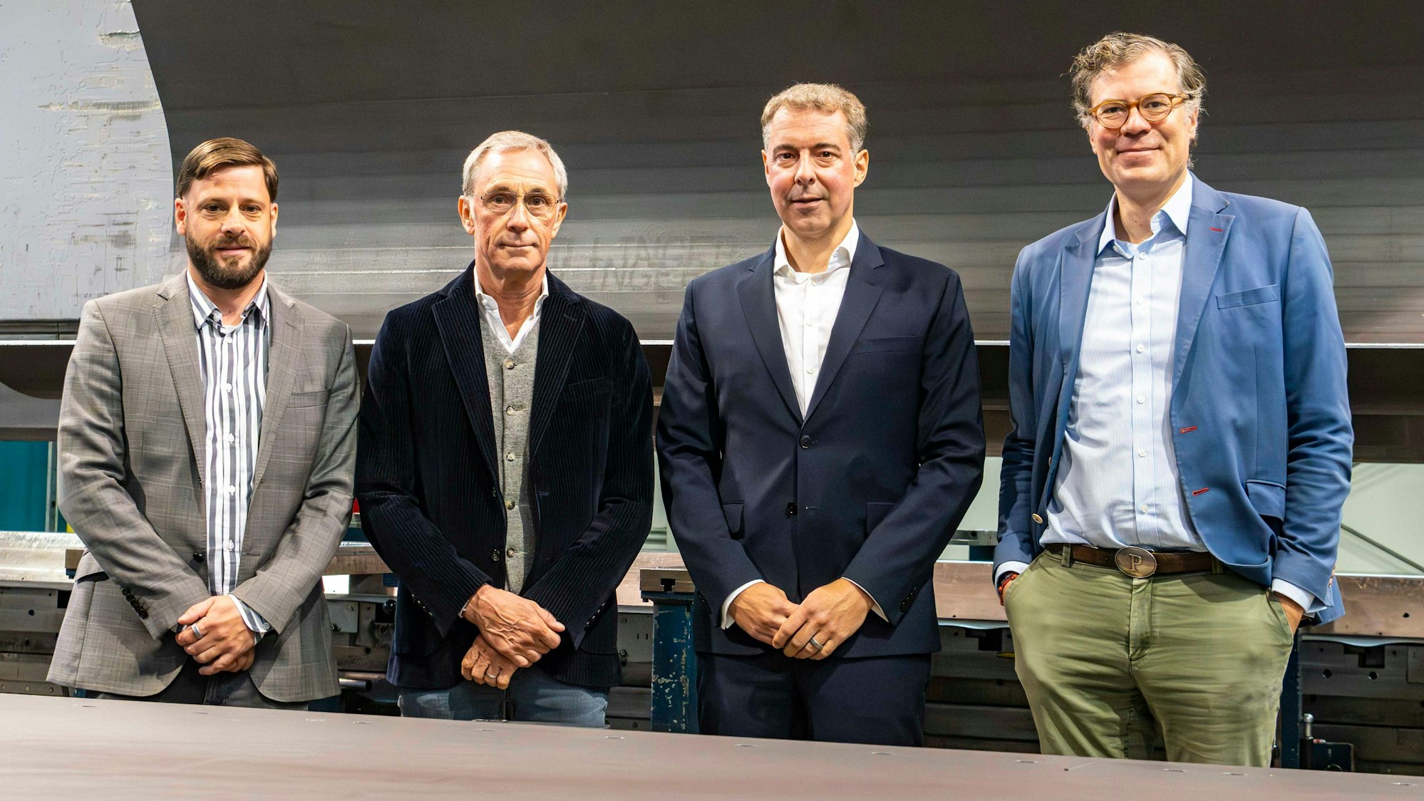 Das Bild zeigt die Obengenannten in einer Halle der Firma.