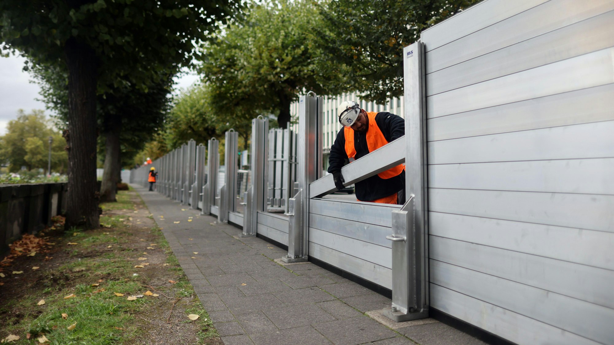 Eine Arbeitskraft der Stadtentwässerungsbetriebe baut die mobilen Wände zum Schutz vor Hochwasser auf.