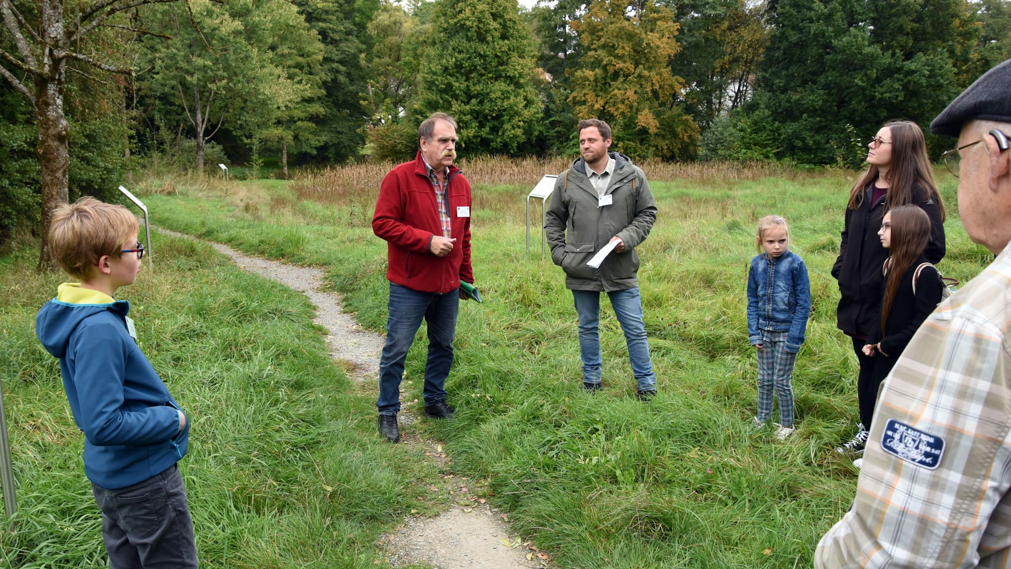 Blick auf zwei Männer, die einer Gruppe etwas erklären.