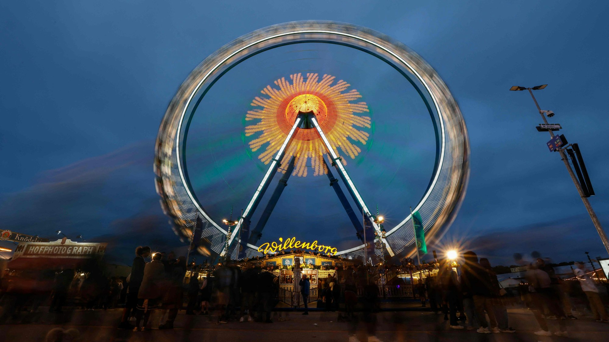 Die Lichter eines Riesenrads leichten während des 190. Oktoberfestes im Vergnügungspark auf der Theresienwiese in München (Symbolbild)