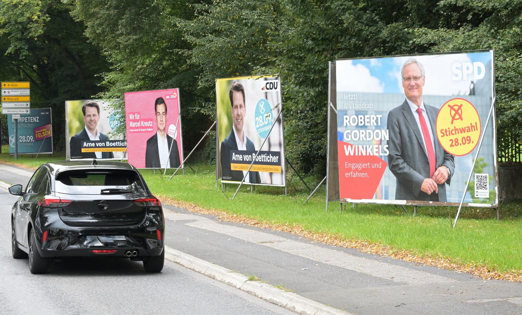 Wahlplakate zur Stichwahl der Kommunalwahl 2025 stehen an der Overather Straße in Bergisch Gladbach-Bensberg.