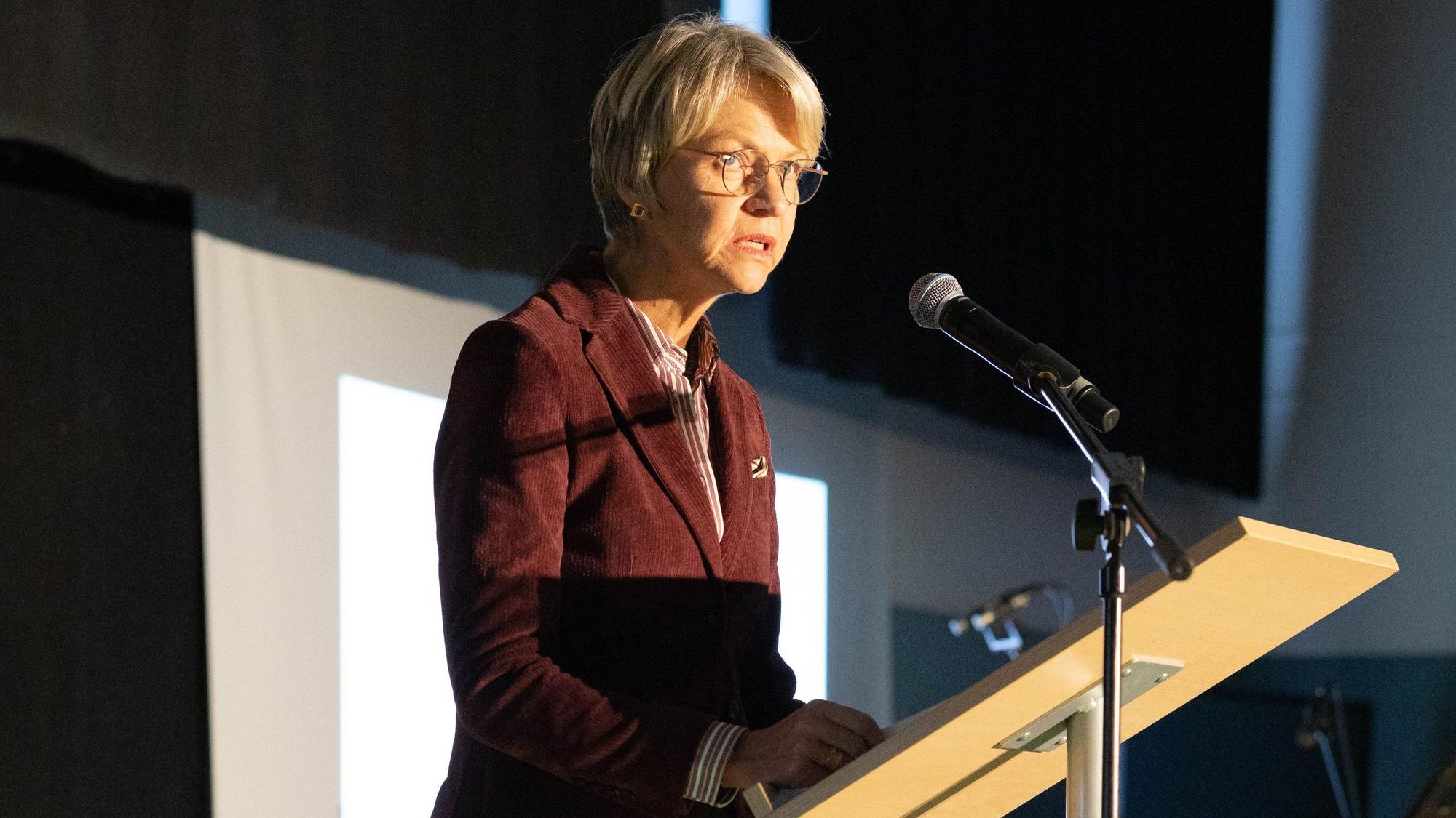 NRW-Schulministerin Dorothee Feller steht an einem Pult und spricht in ein Mikrofon.