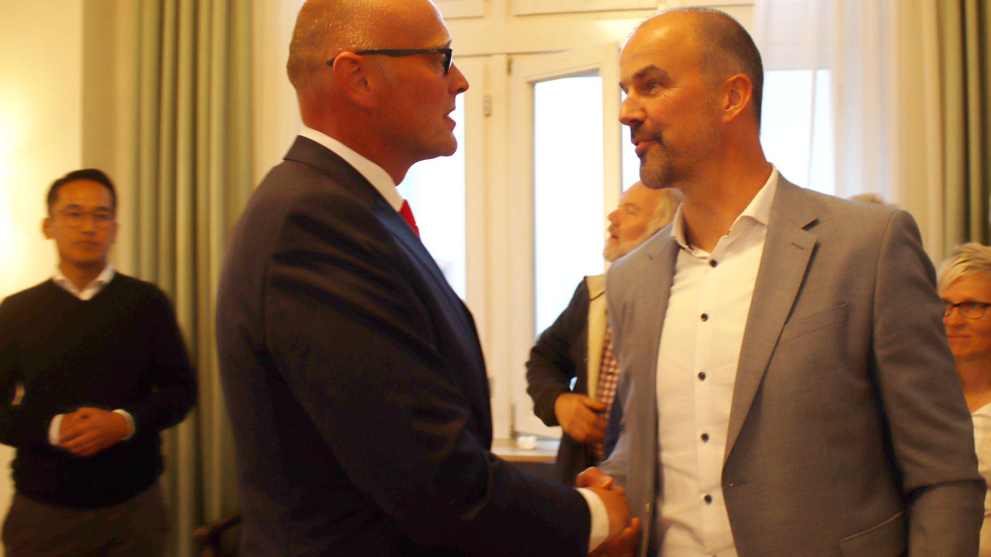 Guido Waters und Sebastian Glatzel schütteln sich die Hände.