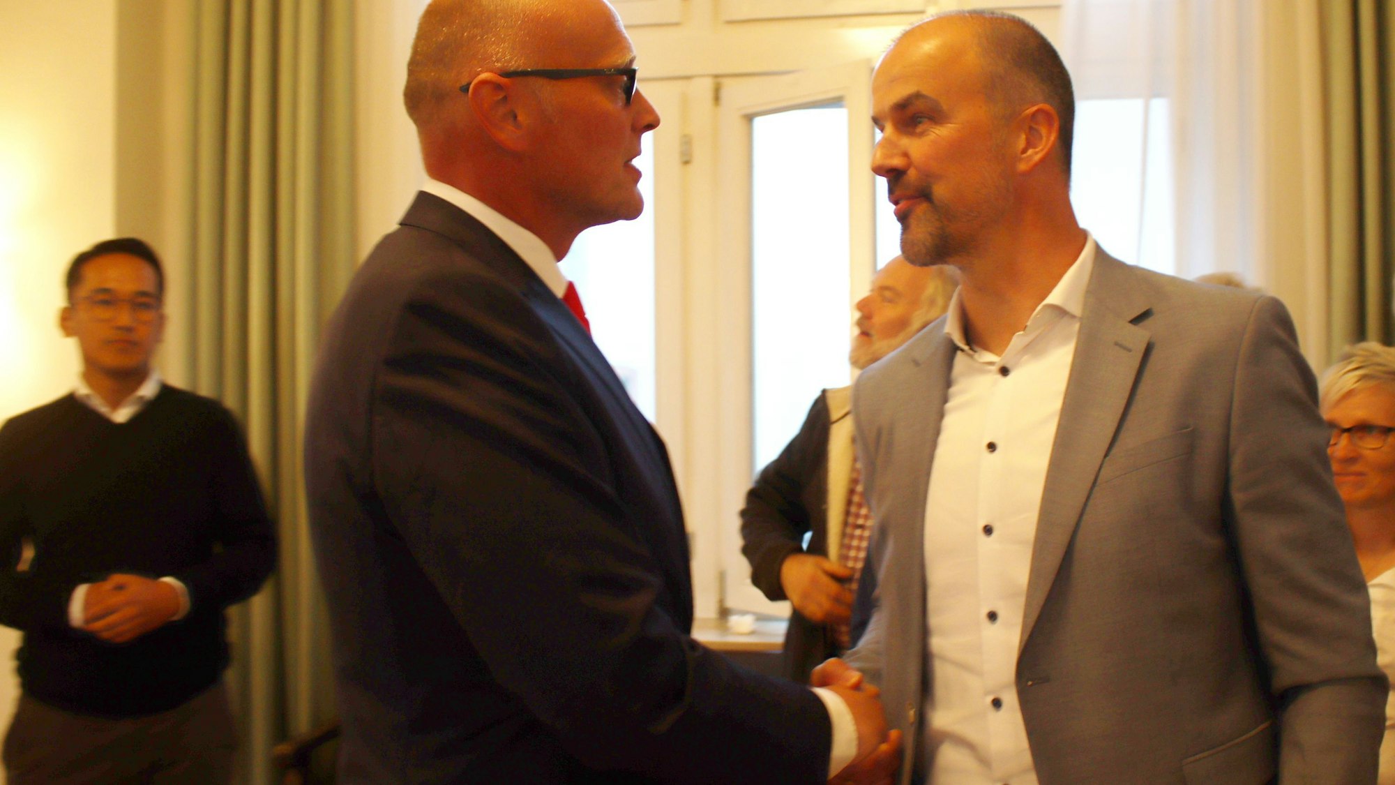 Guido Waters und Sebastian Glatzel schütteln sich die Hände.