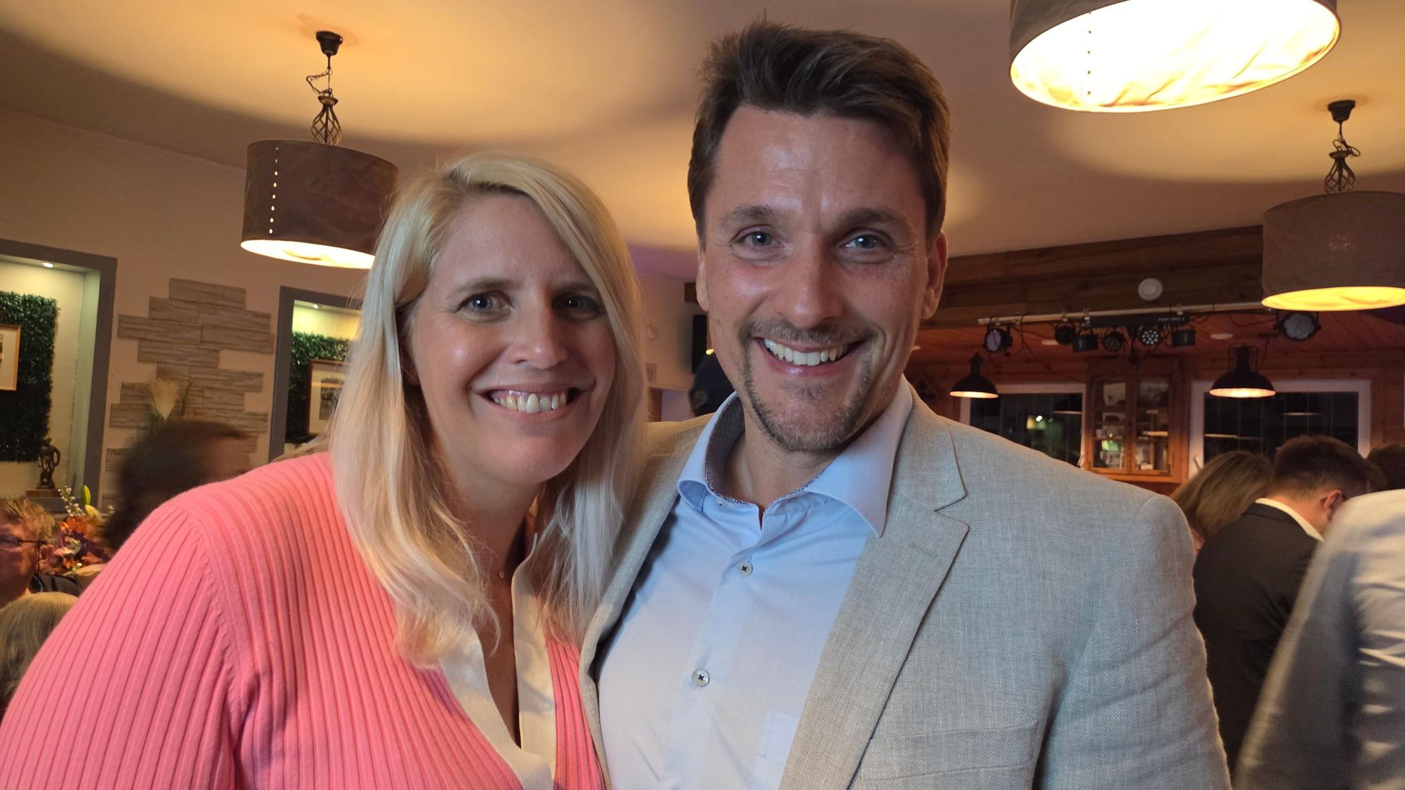 Ein Mann und eine Frau lachen in die Kamera.