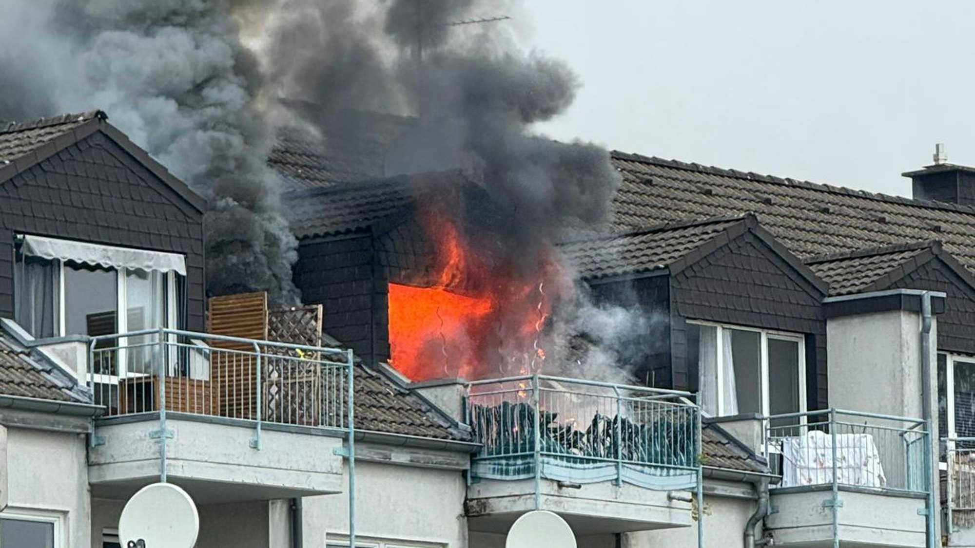 Aus der Dachgeschosswohnung schlagen Flammen.