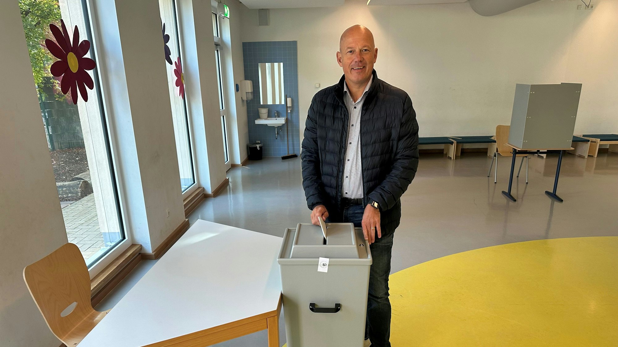 Zu sehen ist Frank Rock, Landrat des Rhein-Erft-Kreises, wie er einen Zettel in eine Wahlurne einwirft.