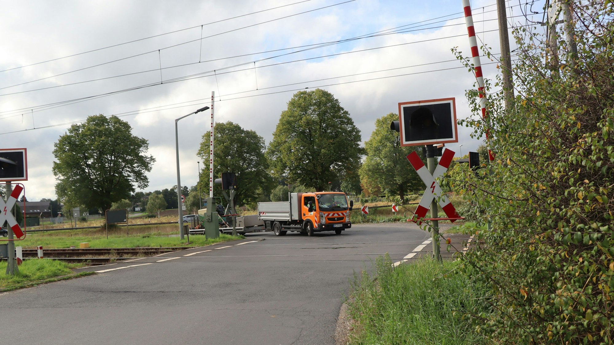 Das Bild zeigt einen Bahnübergang im Grünen.