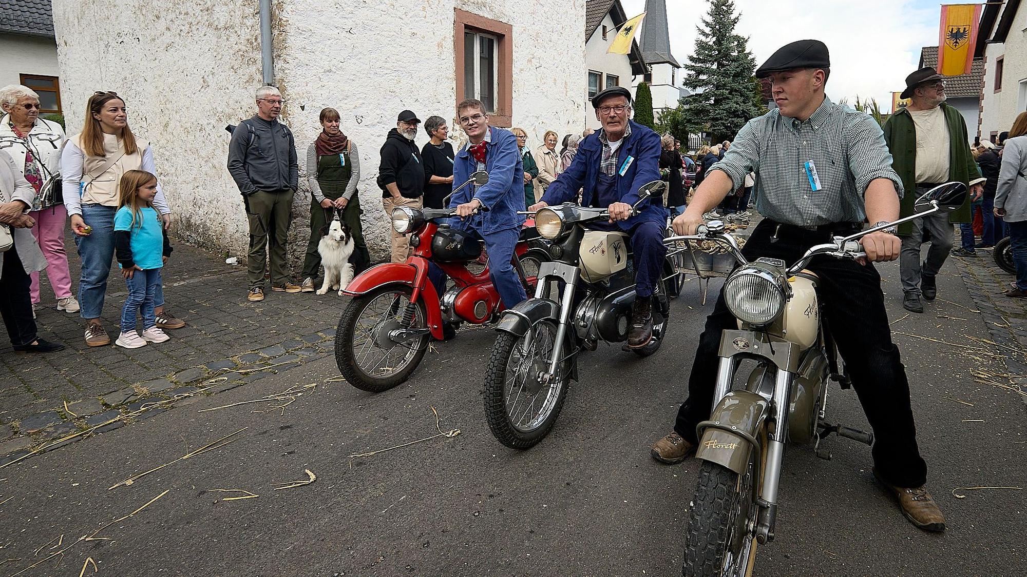 Drei Männer sitzen auf historischen Kreidler-Motorrädern.