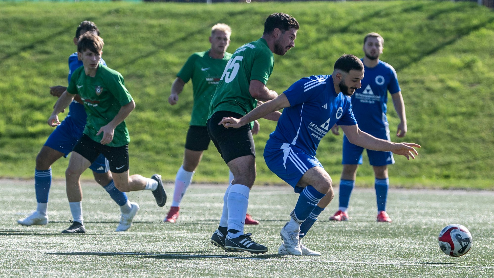 Das Bild zeigt den Obengenannten, der von einem Gegenspieler bedrängt wird.